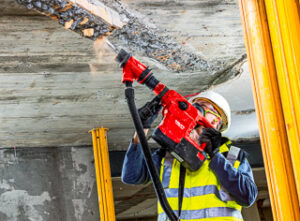 Chlap so zbíjačkou Hilti búra stropnú stenu